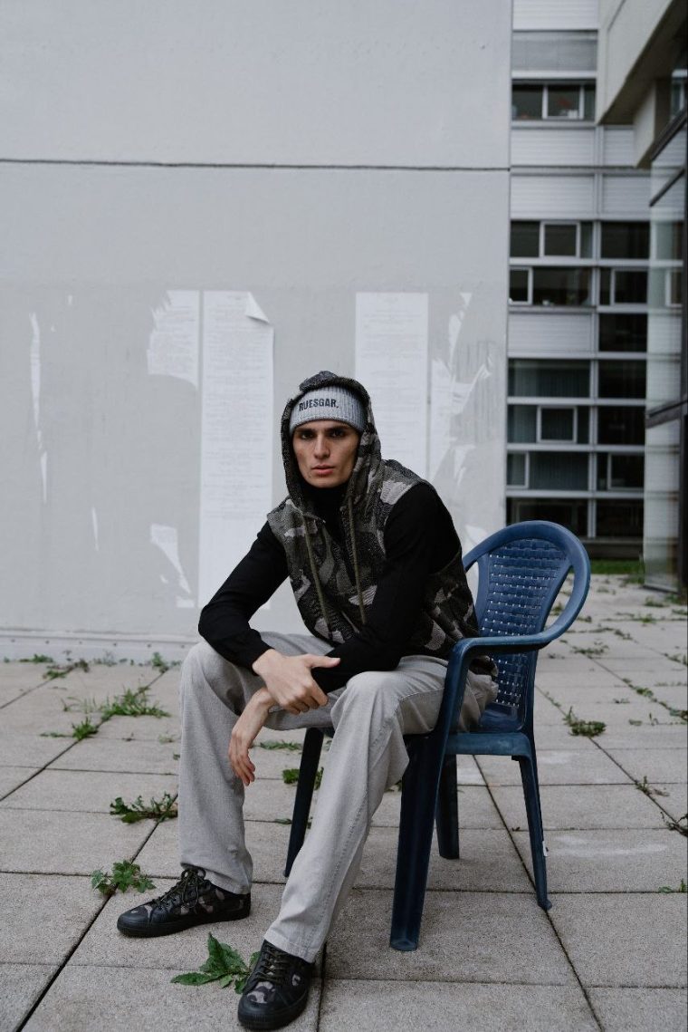 Porträt einer sitzenden Person im urbanen Außenraum